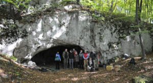 Foto der Forschenden vor dem Eingang zur Maszycka Höhle in Polen